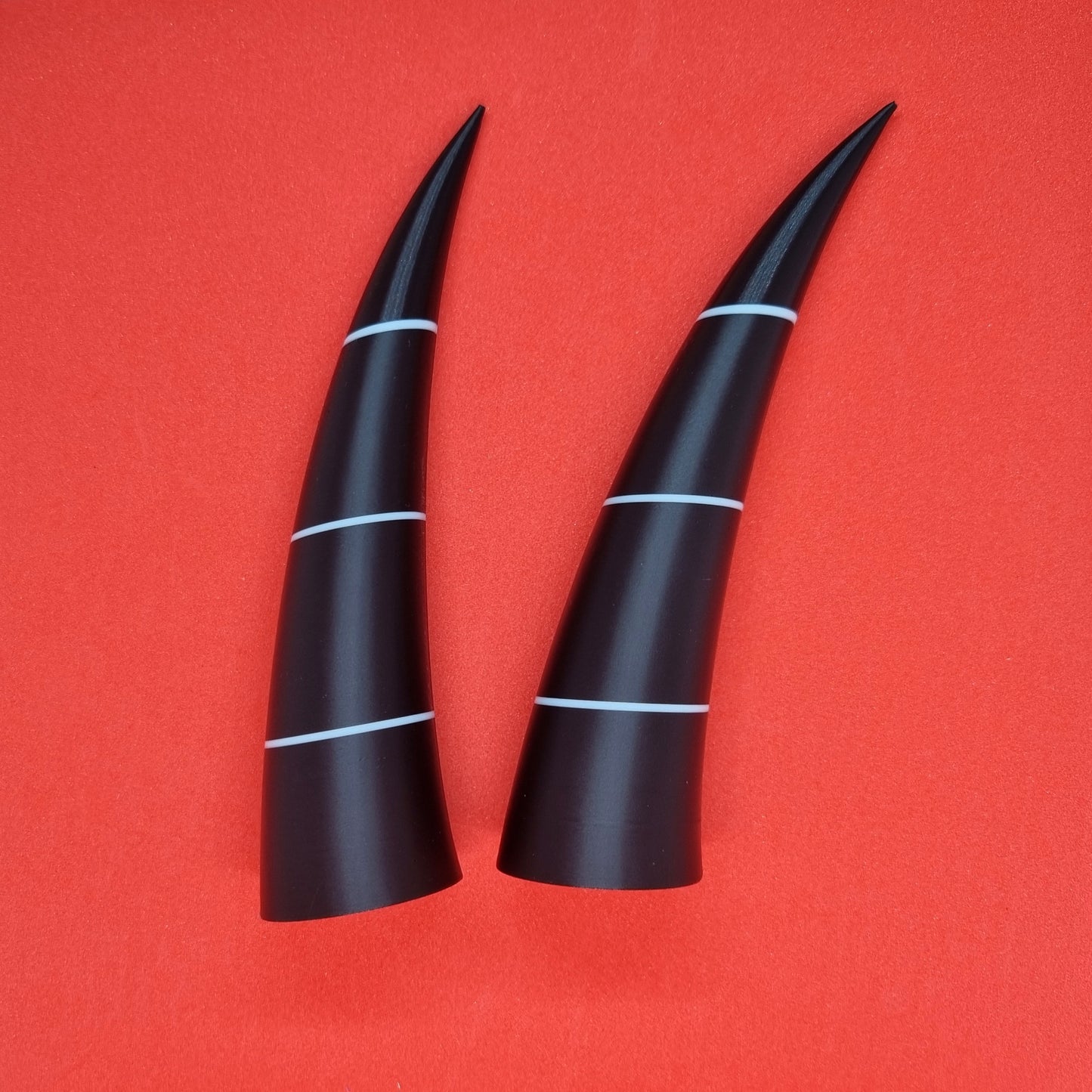 Pair of imp horns (black with white lines)