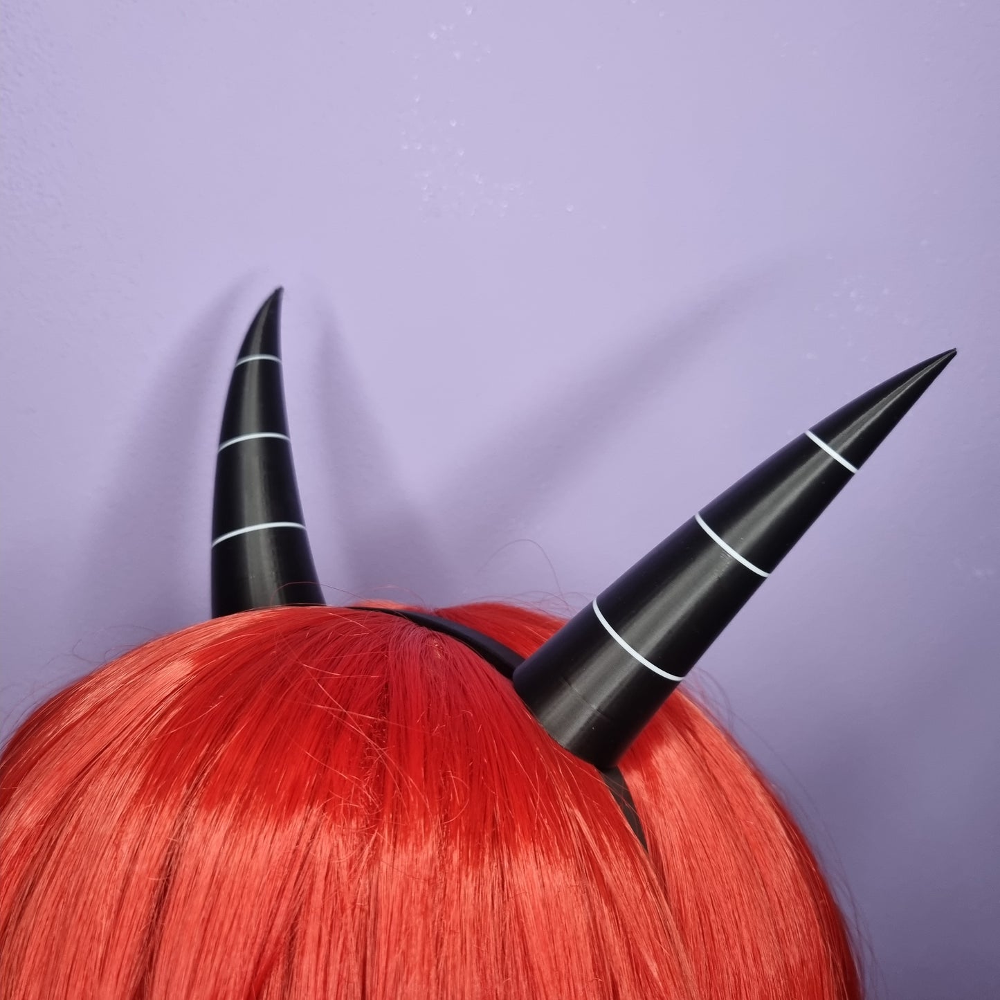 Pair of imp horns (black with white lines)