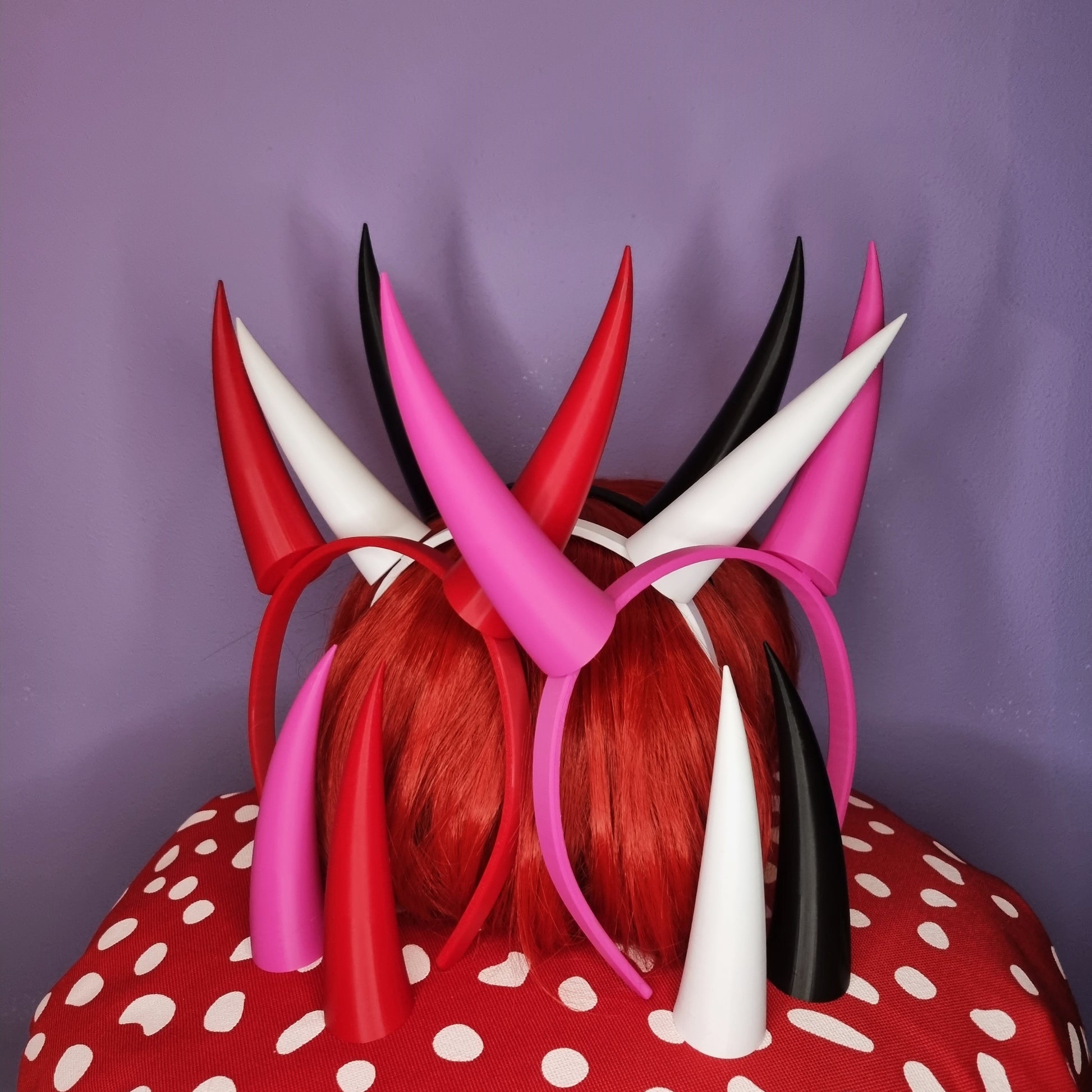 Cosplay horns on headband of red, white, black and pink colors. Red horns are fitting for demon Charlie princess of hell cosplay